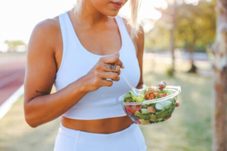 Young female athlete eating healthy after training